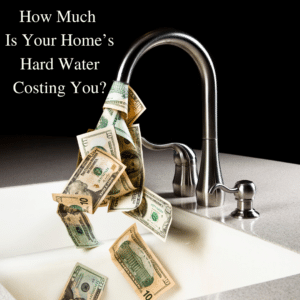 How Much Is Your Home's Hard Water Costing You? Chrome faucet is on and pouring large dollar bills instead of water into white bathroom sink against black background.